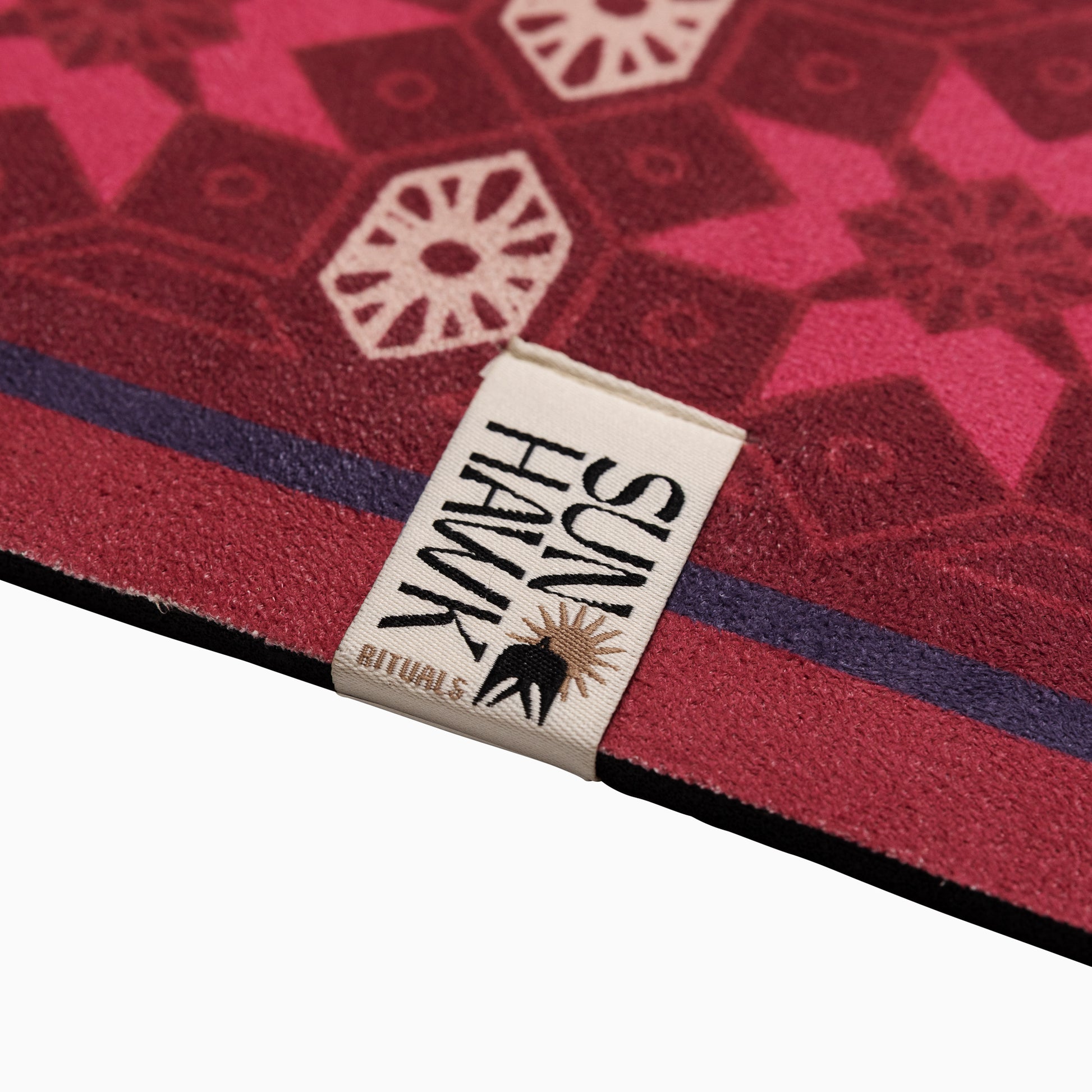 Close-up of a red and pink patterned Australian Yoga mat with a 'SunHawk' label.