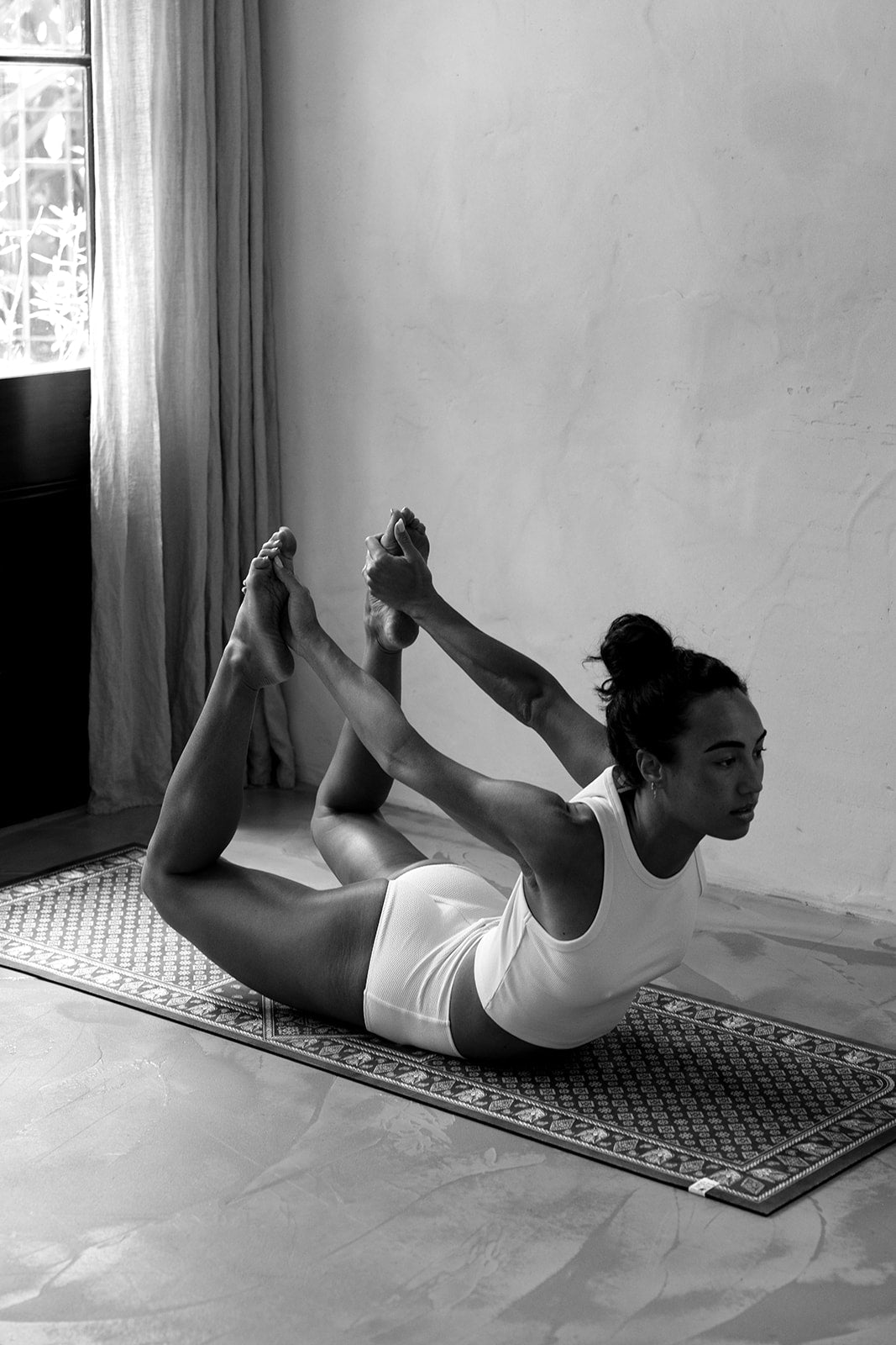 Person practicing yoga on a mat in a home setting
