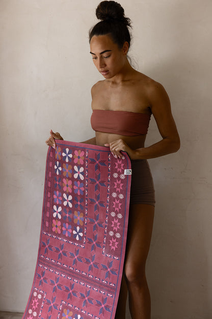 Woman holding an australian designed quality yoga mat with beautiful rich tapestry print