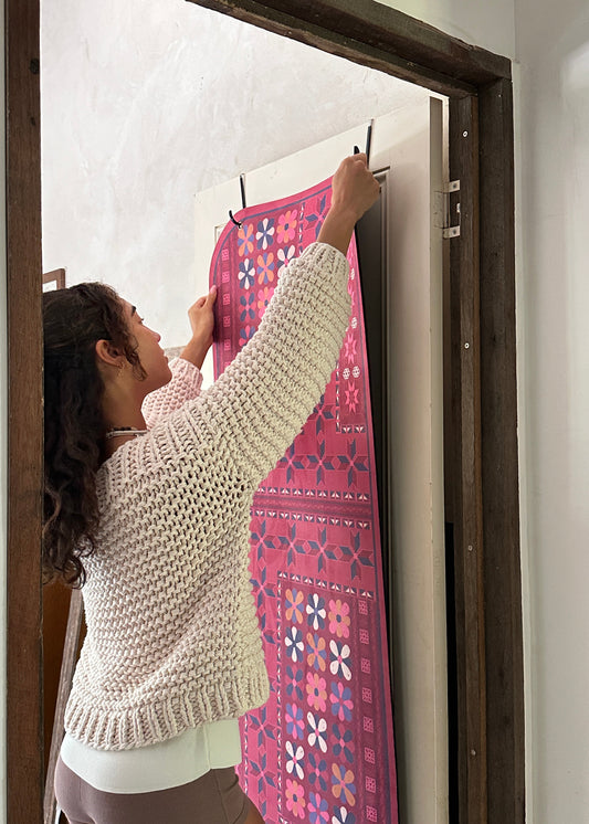 Person hanging a yoga mat on the door